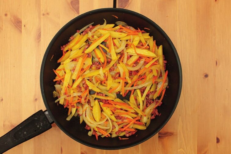 Gemüse mit Speckwürfeln in der Pfanne