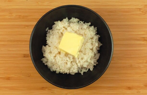 Schale Reis mit einem Stück Butter obenauf