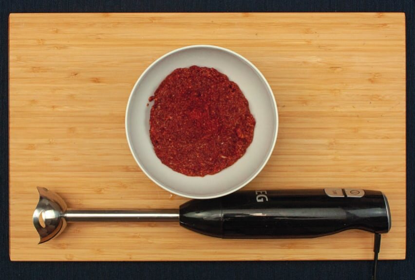 Schale mit roter pürierter Kimchi-Soße, davor ein Stabmixer