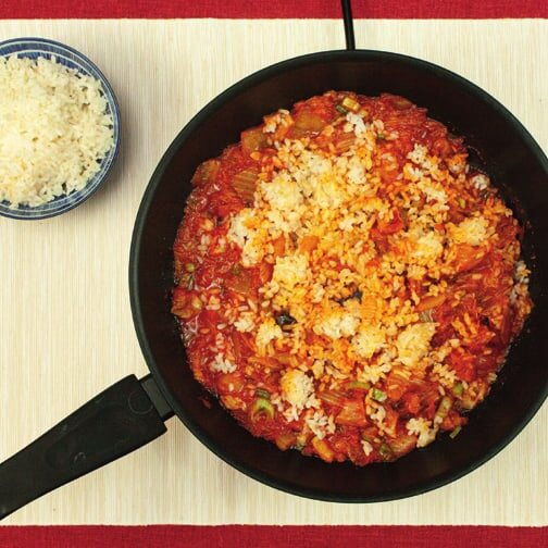 Weißer Reis auf dem Kimchi in der Pfanne, daneben eine Schale Reis